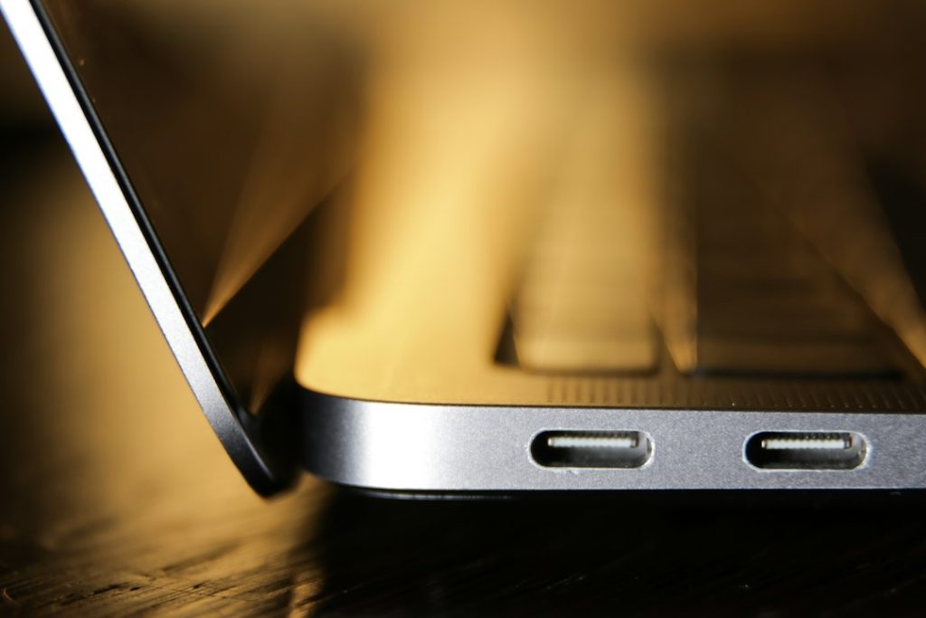 Laptop conectada mediante USB-C a un adaptador de corriente compacto